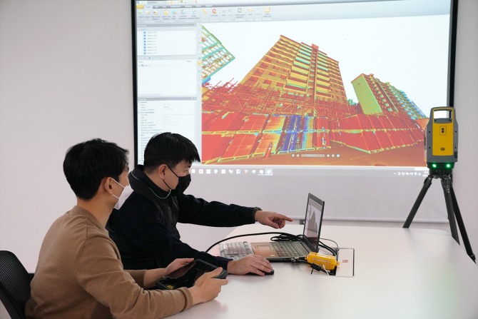 롯데건설 관계자가 3D 스캐너를 활용한 기존 아파트 모델링 데이터를 확인하고 있다. 사진=롯데건설