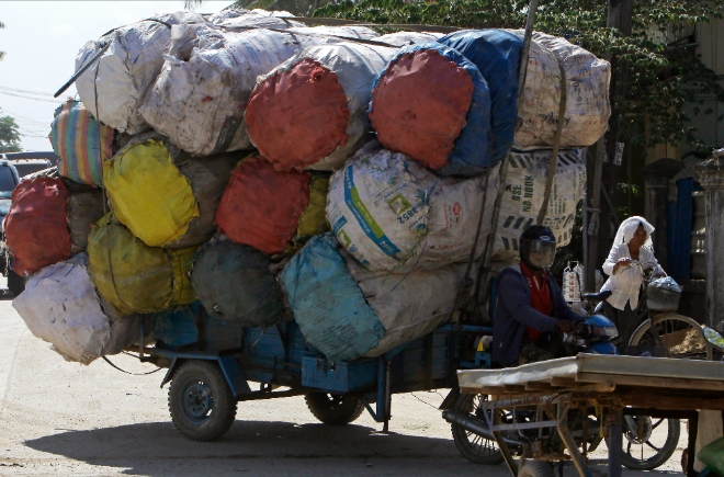 캄보디아 프놈펜에서 한 남성이 철스크랩(고철) 자루들을 수송하고 있다. 사진=뉴시스