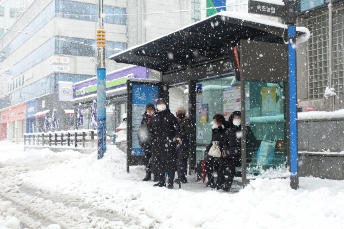 눈이 오는 지난 15일 강원 속초시민들이 속초시 버스정류장에서 버스를 기다리고 있다. 사진=속초시청 제공/뉴시스