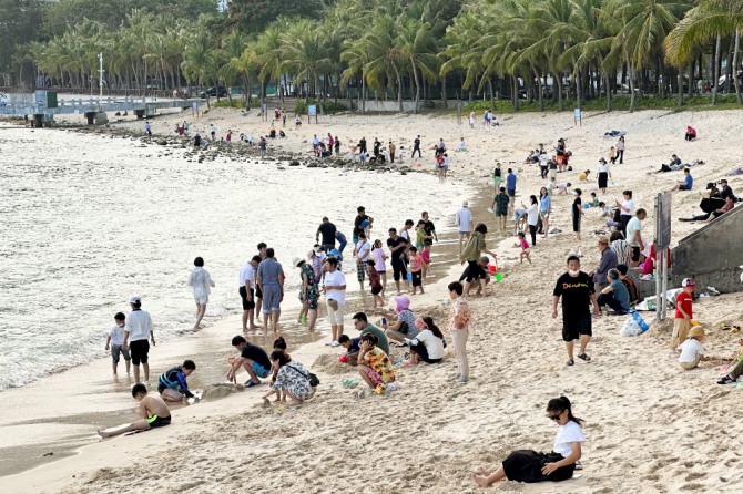1월 23일 중국 하이난성 산야에서 봄 축제와 음력설 연휴 동안 해변에 사람들이 모여 있다. 사진=로이터