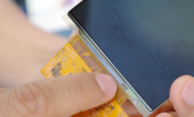 삼성전자 시스템LSI 직원이 디스플레이 구동 칩(패널 아래 붙은 얇고 긴 막대)을 패널과 접합하는 모습을 연출하고 있다. 사진=삼성반도체이야기