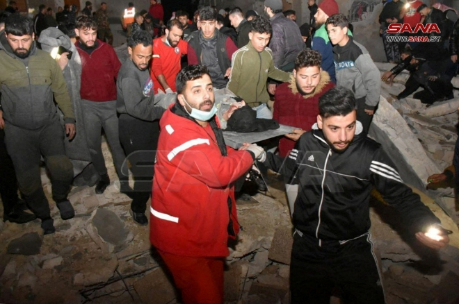 구조대원들이 지진 여파가 미친 시리아 중부 도시 하마의 무너진 건물에서 부상자를 이송하고 있다. 사진=연합뉴스 