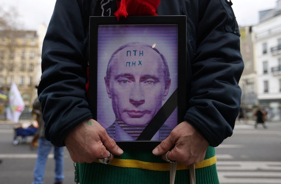 지난달 25일 프랑스 파리에서 러시아의 우크라이나 침공 1주년을 기념하는 집회에 참석한 사람들이 블라디미르 푸틴 러시아 대통령의 사진을 들고 있다. 사진=로이터