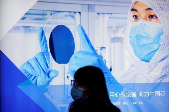2021년 3월 중국 상하이에서 열린 반도체 기술 무역 박람회인 세미콘 차이나(Semicon China)에서 한 여성이 디스플레이 앞을 지나고 있다. 사진=로이터 