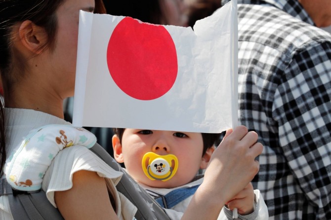 젊은 일본 여성이 갓난 아이를 안고 있다. 사진=로이터