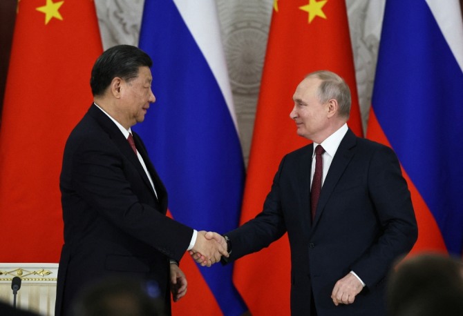시진핑 중국 국가주석(왼쪽)이 푸틴 러시아 대통령을 만나 악수하고 있다. 사진=로이터