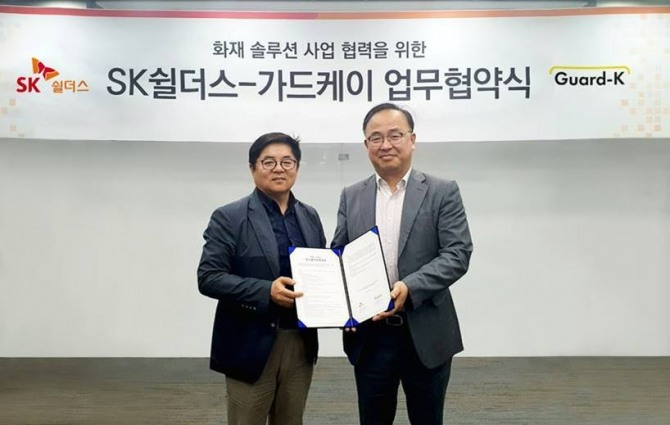 지난 8일 SK쉴더스와 가드케이가 화재 예방 및 대응 관련 안전 솔루션 사업 협력을 위한 업무협약을 체결했다. 김영주 SK쉴더스 융합보안사업 본부장(왼쪽)과 조욱래 가드케이 대표가 사진 촬영을 하고 있다. 사진=SK쉴더스