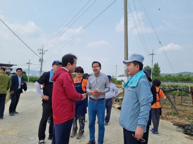 김충섭(빨강옷)김천시장이 재경김천향우회 김현태(오른쪽)회장에게 고향일손돕기에 먼곳까지 찾아 일손을 도와줘 고맙다며 인사를 하고 있다. (사진=재경김천향우회)