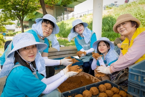 코웨이 임직원 봉사자가 EM흙공을 제작하고 있다. 사진=코웨이.