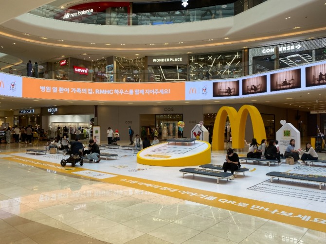 한국맥도날드가 간병 문화 개선과 로날드 맥도날드 하우스 제 2호점 건립을 위해 진행 중인 '0.3평 엄마의 침대' 기부 캠페인 현장에서 시민들이 인터뷰 영상 등을 관람하고 있다. 사진=송수연 기자