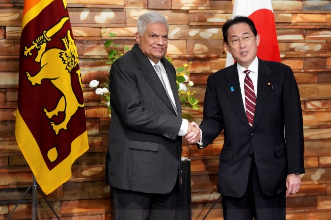 25일(현지시간) 스리랑카 대통령과 일본 총리가 회담에 앞서 악수했다. 사진=로이터