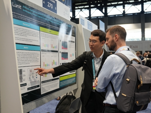 최근 미국 시카고에서 열린 미국 임상종양학회(ASCO 2023)에서 다국적 제약회사 '아스트라제네카' 관계자(오른쪽)가 루닛 연구 결과에 관한 설명을 듣고 있다. 사진=루닛