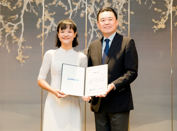 김인규 하이트진로 대표(오른쪽)가 베트남 대학생에게 장학금을 전달하고 있다. 사진=하이트진로.