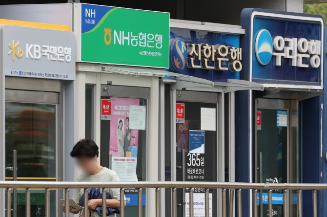 '청년도약계좌'가 사흘째 누적 가입자 21만명을 넘어서며 순항하고 있다. 은행 기기 앞을 지나가는 행인. 연합