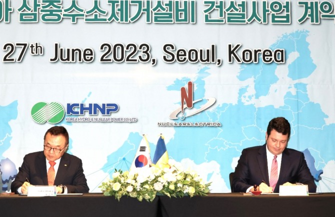 황주호(왼쪽) 한국수력원자력 사장과 코스민 기처 루마니아 원자력공사(SNN) 사장이 27일 서울 포시즌스호텔에서 루마니아 원전 삼중수소제거설비 건설 계약서에 서명하고 있다. 사진=연합