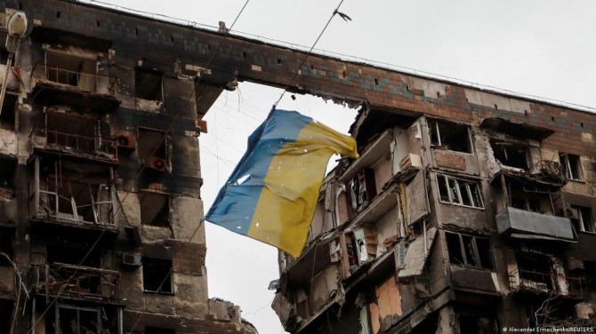 러시아의 폭격으로 무너진 주택에 우크라이나 국기가 걸려 있다. 사진=로이터