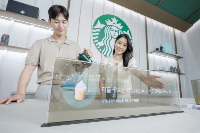 16일 서울 코엑스에서 열린 ‘K디스플레이 2023’ 전시회에서 LG디스플레이 모델이 스타벅스와 협업한 매장용 투명 OLED 콘셉트를 소개하고 있다. 사진=LG디스플레이