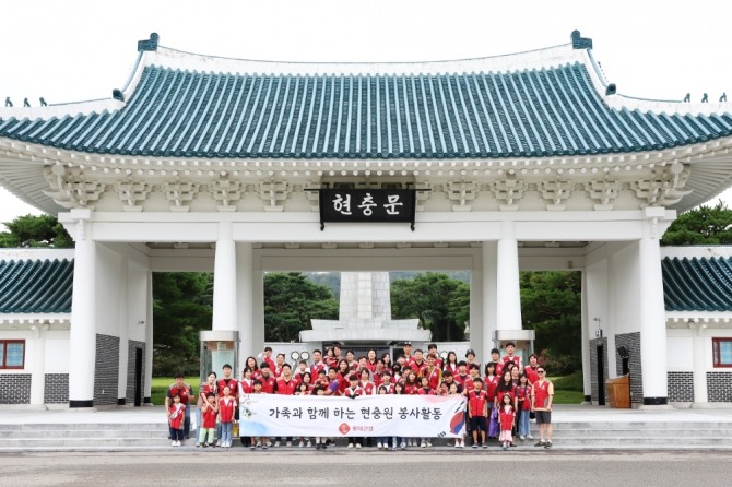 롯데건설 임직원과 가족들이 현충문 앞에서 봉사활동 후 기념 촬영을 하고 있다. 사진=롯데건설