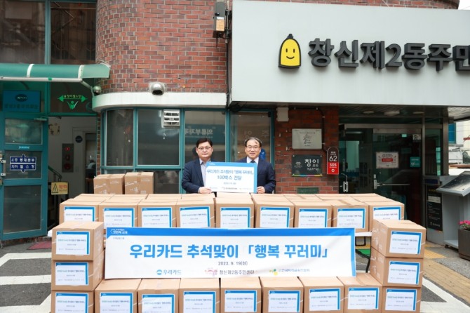 지난 19일 종로구 창신2동 주민센터에서 진행된 행복꾸러미 100개 전달 행사에서 우리카드 이재일 경영기획본부장(왼쪽)과 마호식 창신2동장이 기념사진을 촬영하고 있다. 사진=우리카드 제공.