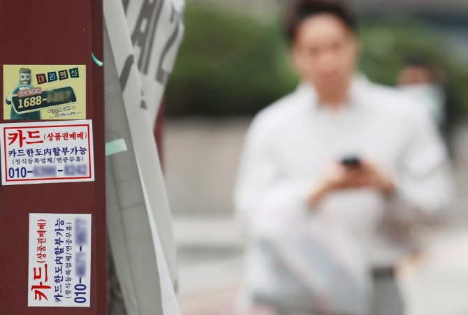 거리에 붙어 있는 카드대출 안내 스티커. 사진=연합뉴스.