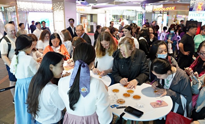 지난 26일 방한 외국인 고객들이 롯데면세점 명동본점 앞에서 달고나뽑기, 제기차기 등 다양한 한국 민속놀이를 체험하고 있다.  /사진=롯데면세점