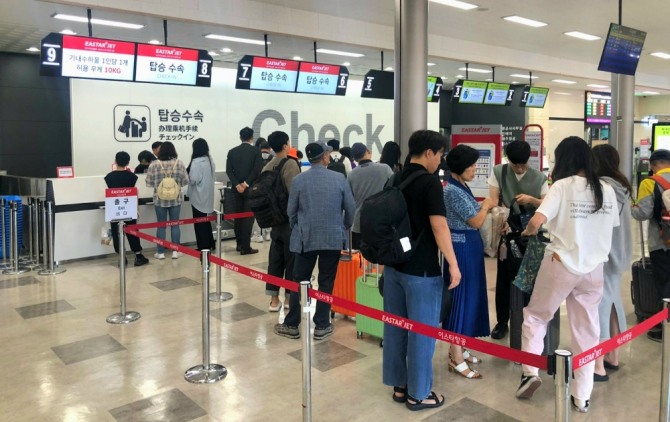 이스타항공 군산공항 카운터 앞에서 승객들이 탑승 수속을 하고 있다. 사진=이스타항공