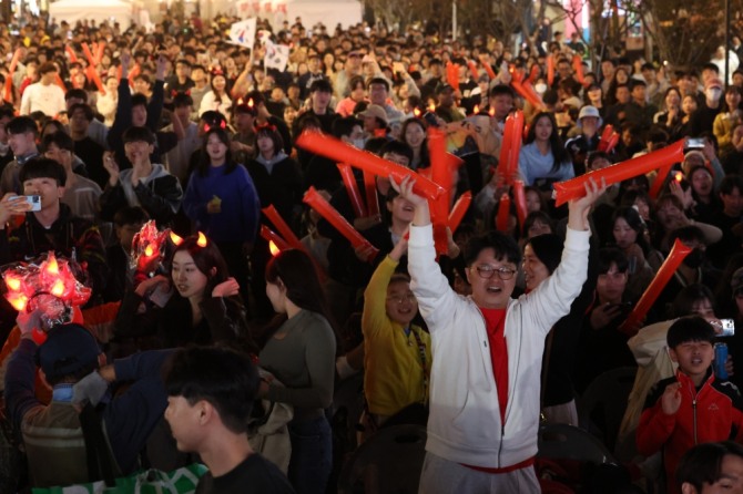 19회 항저우 아시안게임 남자 축구 결승전이 열리는 7일 오후 서울 마포구 홍대 레드로드에서 거리 응원에 나선 축구팬들이 한국 정우영이 골을 넣자 기뻐하고 있다. 사진=연합뉴스