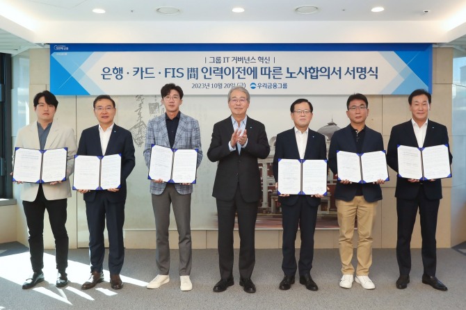 우리금융그룹(회장 임종룡)은 20일 우리금융 본점에서 IT 거버넌스 개편을 위한 노사합의 서명식을 진행했다. 왼쪽부터 장문열 우리카드 노조위원장, 고정현 우리에프아이에스 대표, 박봉수 우리은행 노조위원장, 임종룡 우리금융그룹 회장, 조병규 우리은행장, 이호성 우리에프아이에스 노조위원장, 박완식 우리카드 대표가 기념촬영을 하고 있다. 사진=우리금융
