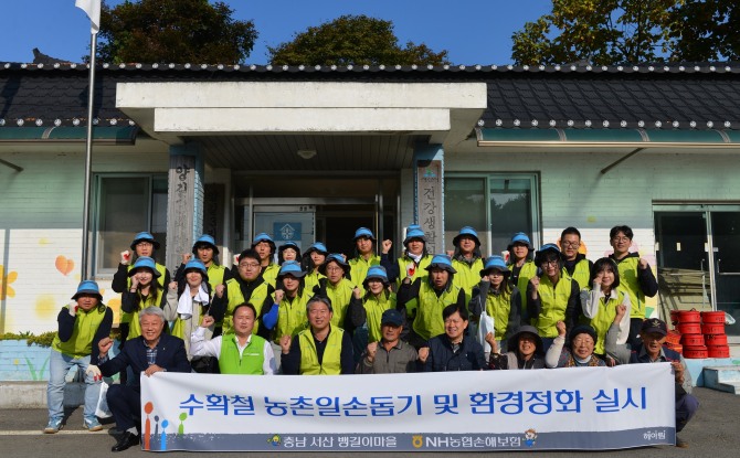 농협손보 강필규 경영기획부문 부사장(앞줄 왼쪽 세번째)이 헤아림봉사단 및 마을주민들과 기념촬영을 하고 있다. 사진=NH농협손보 제공.