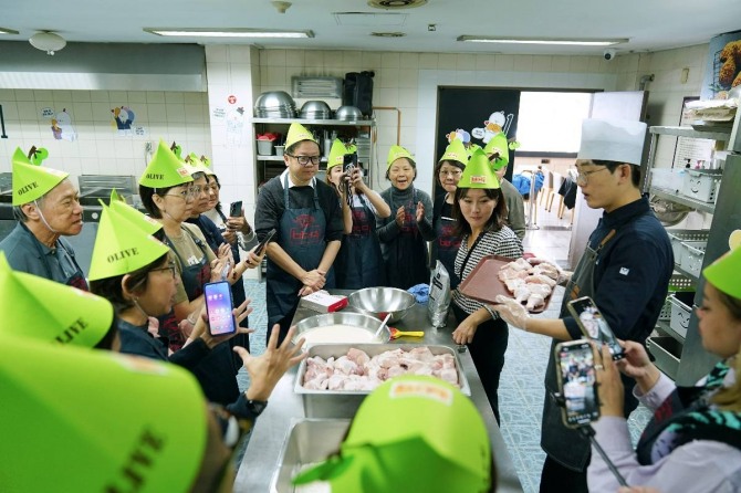 한국을 방문한 싱가폴 관광객들이 BBQ 치킨대학의 치킨캠프에 참여해 BBQ 황금올리브 치킨 조리 방법을 배우고 있다.  /사진=BBQ