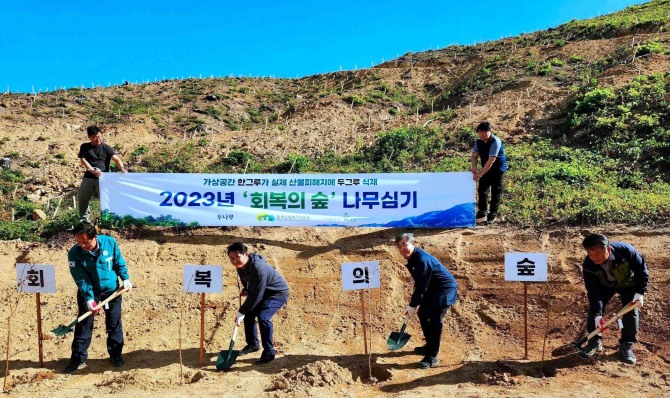 지난 3일 경북 울진에서 열린 ‘회복의 숲’ 식수 행사에서 두나무, 한국산림복지진흥원 등 관계자들이 나무를 심고 있다. 사진=두나무