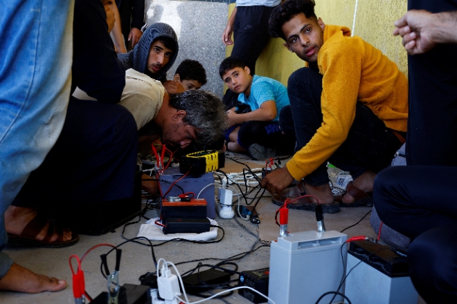 지난달 19일(현지시간) 이스라엘의 잇단 보복 공습으로 통신망이 크게 붕괴된 가자지구의 가전제품 매장에 주민들이 몰려들어 태양광 충전기를 이용해 핸드폰을 충전하고 있다. 사진=로이터