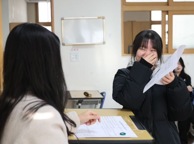 2024학년도 대학수학능력시험 성적통지표 배부일인 8일 청주 서원고등학교 3학년 교실에서 학생이 수능 성적을 확인한 뒤 웃고 있다. 사진=연합뉴스