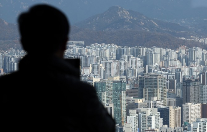 한국은행이 13일 발표한 '금융시장 동향'에 따르면 11월 말 기준 예금은행의 가계대출(정책모기지론 포함) 잔액은 1091조9000억원으로 한 달 전보다 5조4000억원 늘었다. 이날 오전 서울 영등포구 여의도 63빌딩 전망대에서 한 시민이 서울 시내를 내려다 보고 있다. 