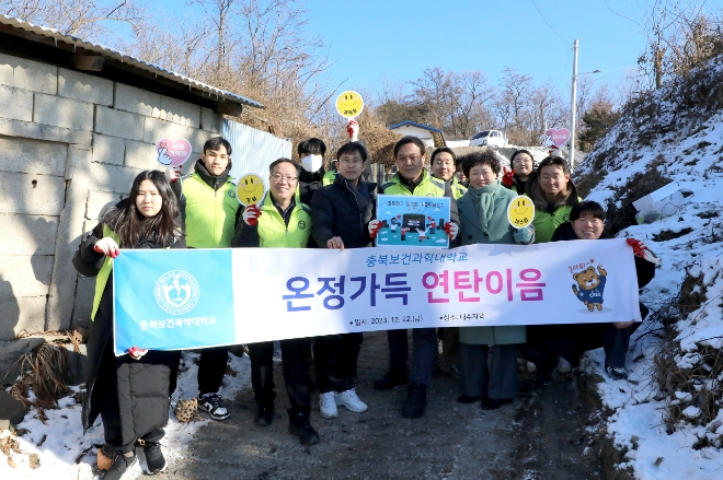 충북보건과학대학교 봉사단이 22일 내수읍 지역 주민들에게  연탄배달 봉사활동을 하기 앞서 기념촬영하고 있다. 사진=충북보건과학대