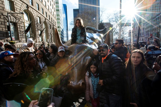 29일(현지시간) 미국 뉴욕증권거래소(NYSE) 금융가의 돌진하는 황소를 방문하는 시민들. 사진=로이터