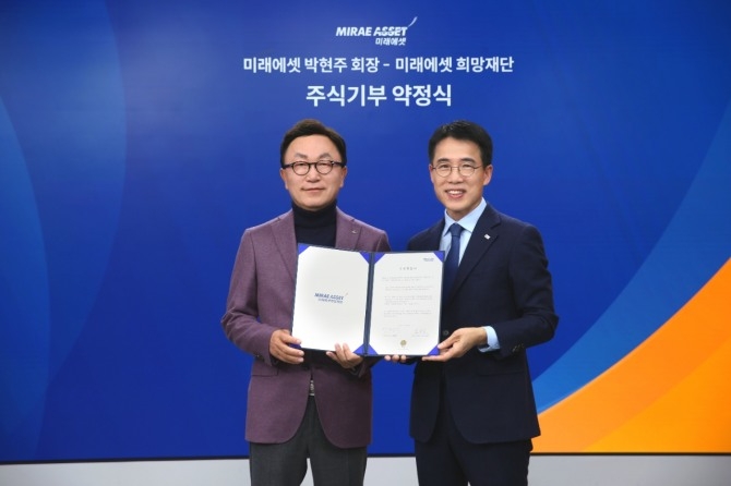 미래에셋 박현주 회장(왼쪽)이 지난해 12월 미래에셋센터원에서 미래에셋희망재단과 주식 기부약정서 체결 기념사진을 찍고 있다. 사진=뉴시스