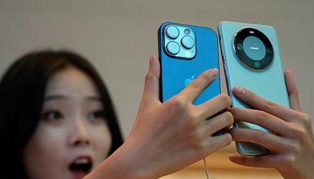 애플 '아이폰15 프로'와 화웨이 '메이트 60 프로'를 함께 들고 있는 중국 여성. 사진=연합뉴스