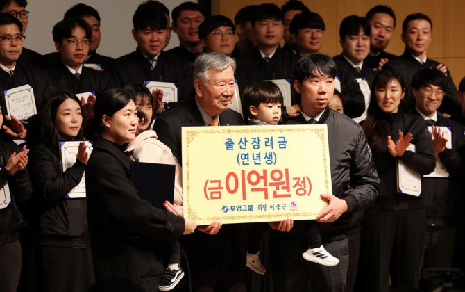 이중근 부영그룹 회장(사진 중앙)이 5일 오전 서울 중구 부영빌딩에서 열린 시무식에서 연년생 가족에게 출산장려금을 전달한 뒤 기념촬영을 하고 있다.  사진=연합뉴스