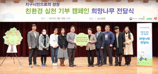 19일 서울 광화문 교보생명 본사에서 열린 '친환경 실천 기부 캠페인 희망나무 전달식'에서 관계자들과 친환경 실천 및 기부 우수 참가자 등이 기념촬영을 하고 있다. (사진 왼쪽 네 번째부터) 환경부 노현진 사무관, 교보생명 장진모 전무, 글로벌비전 김지영 사무총장, 국가환경교육센터 김인호 센터장. 사진=교보생명 제공.