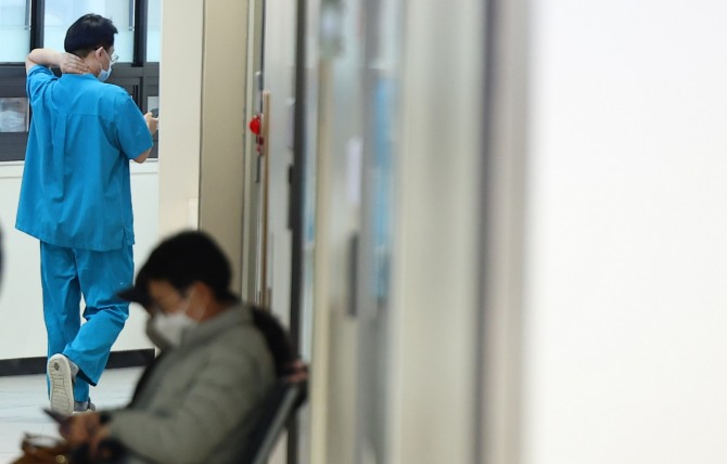 정부의 의대 정원 증원 정책에 반발한 전공의들의 집단행동 사흘째인 22일 오전 서울의 한 공공 병원에서 의료진이 뒷목을 잡고복도를 이동하고 있다. 사진=연합뉴스