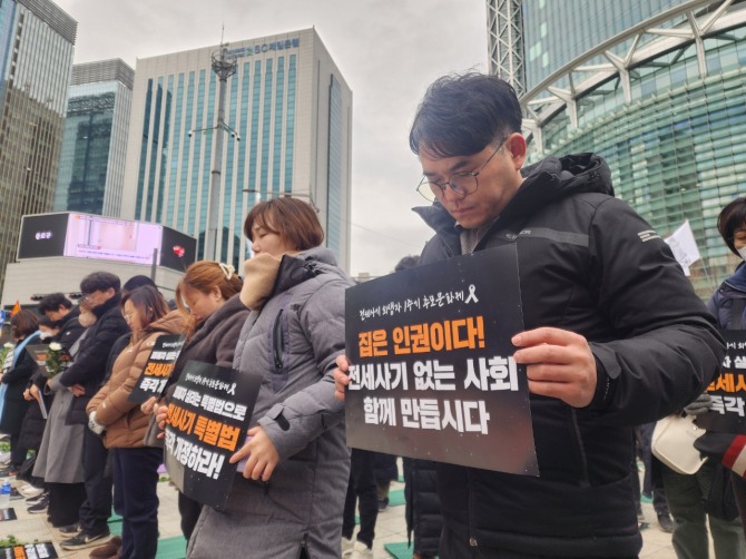 인천에서 2천채가 넘는 주택을 보유하며 전세 사기를 벌인 이른바 ‘건축왕’으로부터 보증금을 돌려받지 못하고 세상을 등진 피해자의 1주기를 앞두고 지난 24일 서울 종로구 보신각에서 열린 추모제에서 참가자들이 희생자를 추모하는 묵념을 하고 있다. 사진=연합뉴스.