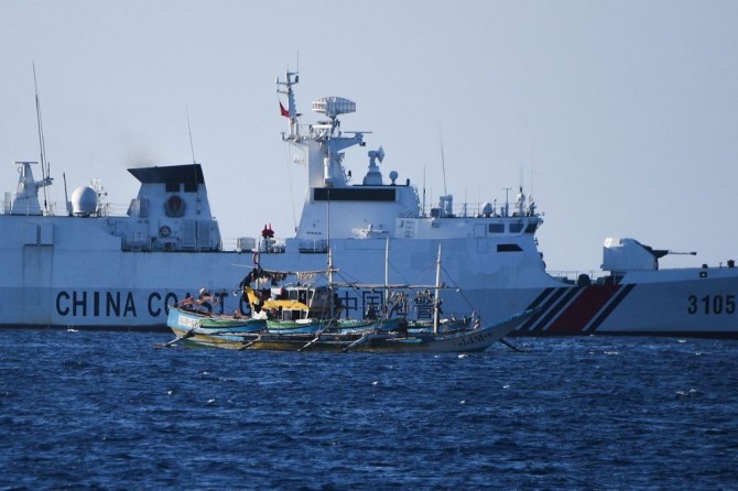 중국 해안 경비대 선박이 스카버러 암초 인근에서 조업중인 필리핀 어선 근저를 지나는 모습.  사진=AFP/연합뉴스