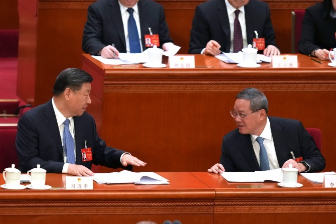 시진핑 중국 국가주석(왼쪽)이 8일(현지 시간) 베이징 인민대회당에서 열린 전국인민대표대회(전인대) 2차 전체회의에 참석해 옆자리의 리창 총리와 대화하고 있다. 사진=AP/연합뉴스