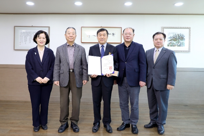 충북보건과학대학교 반도체기계과 최한규(가운데) 교수가 지난 12일 열린 정년 퇴임식에서 대통령 표창을 받은 뒤 기념촬영하고 있다. 사진=충북보건과학대 