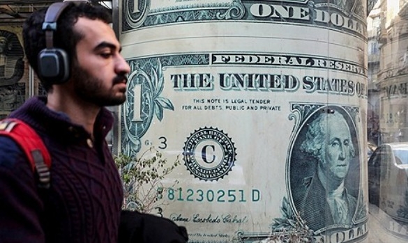 이집트에서 한 남성이 미국 달러의 이미지를 보여주는 환전소 앞을 지나가고 있다.     사진=로이터/연합뉴스