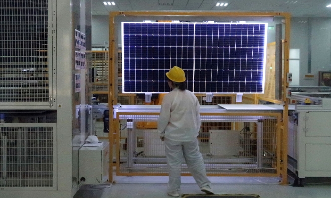 중국 산시성 시안시에 있는 롱기의 태양광 패널 공장에서 한 근로자가 갓 완성된 태양광 모듈을 살피고 있다. 사진=로이터