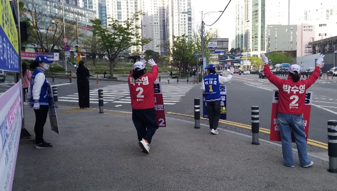 6일 부산 남구 대연동 인근 건널목에서 박재호 부산 남구 더불어민주당 후보 선거운동원들과 박수영 국민의힘 선거운동원들이 유권자들에게 지지를 호소하고 있다. 사진=강경호 기자