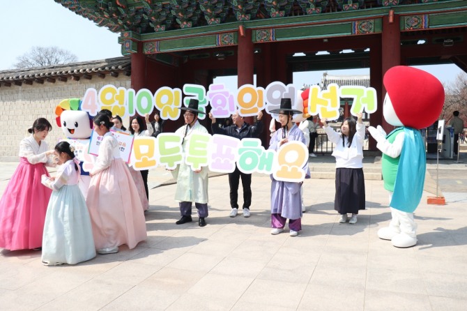 서울시선관위가 한복을 입은 시민과 자녀에게 홍보리플릿과 홍보물품을 나눠주고 있다. 사진=노춘호 기자