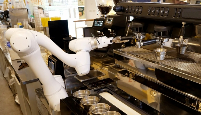 두산로보틱스 협동로봇이 원두가 담긴 포터필터를 커피머신에 장착하고 있다. 사진=두산로보틱스
